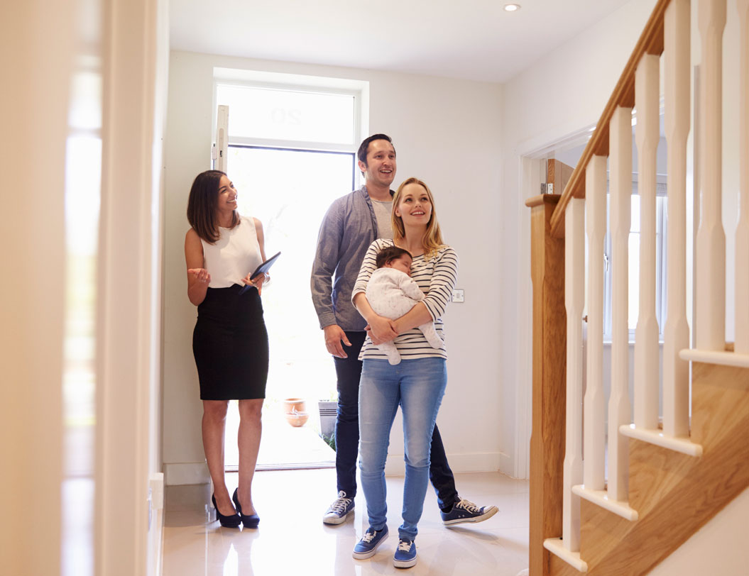 Realtor showing couple with young child a home