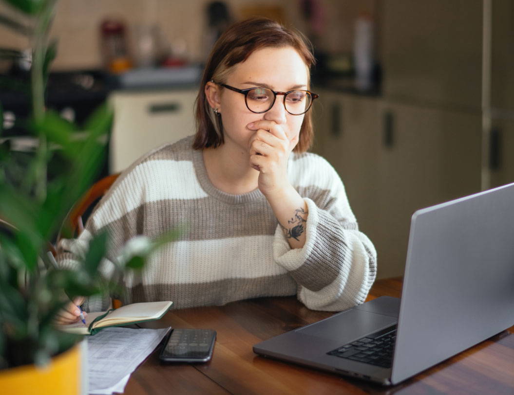 Concerne woman looking at laptop