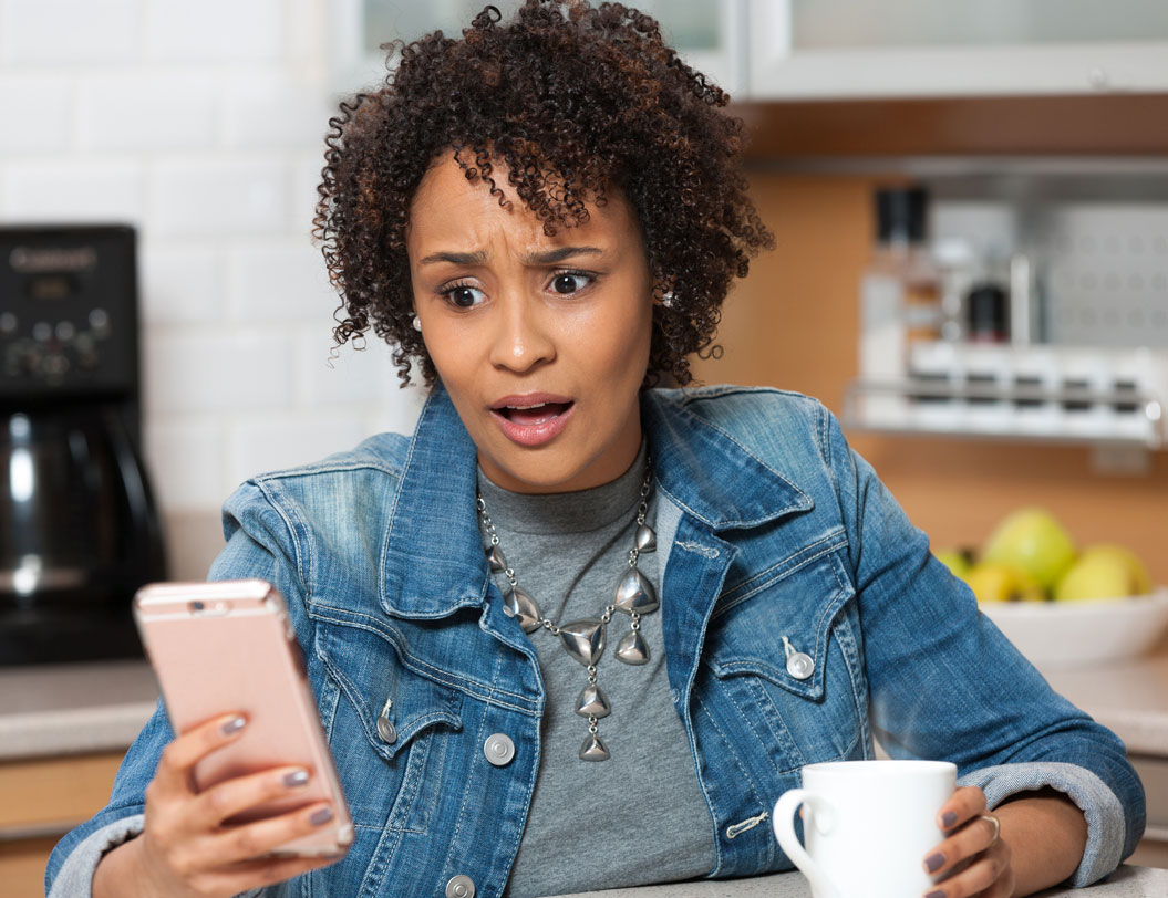 Surprised woman looking at mobile device