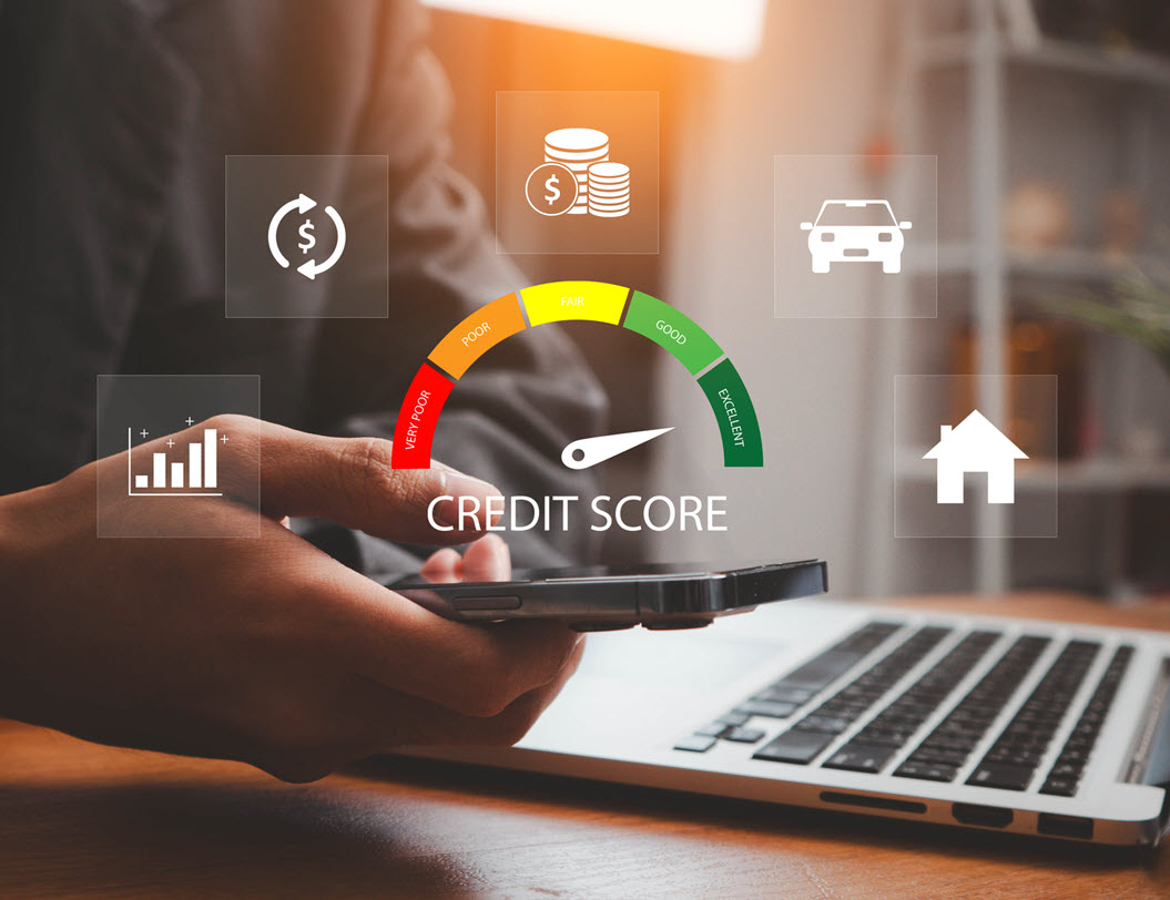credit score monitor hovering over a keyboard and mobile device