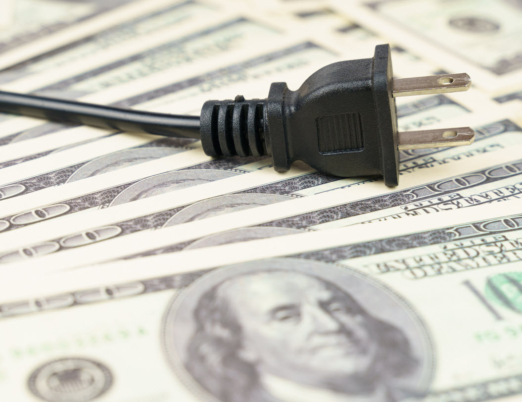 a plug and cord on top of a stack of one hundred dollar bills