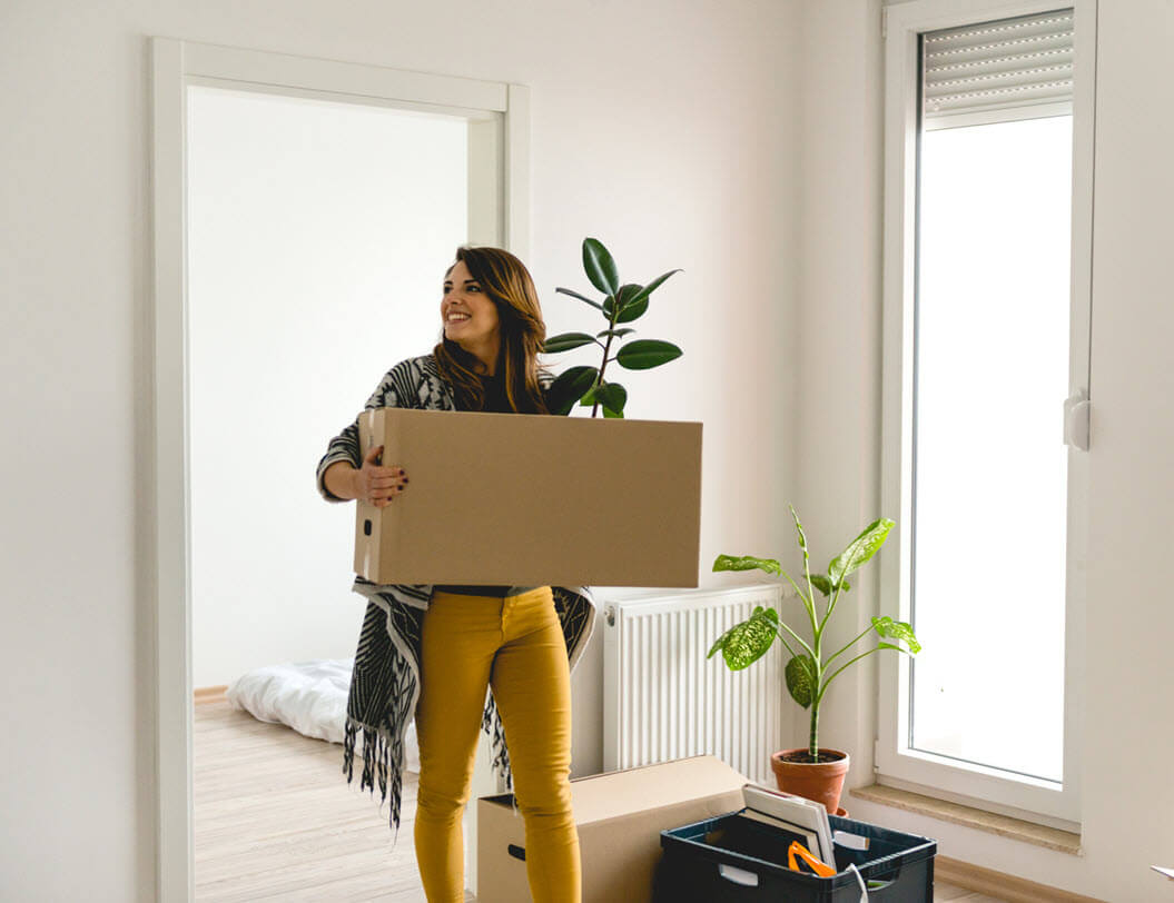 Woman moving into home carrying a box