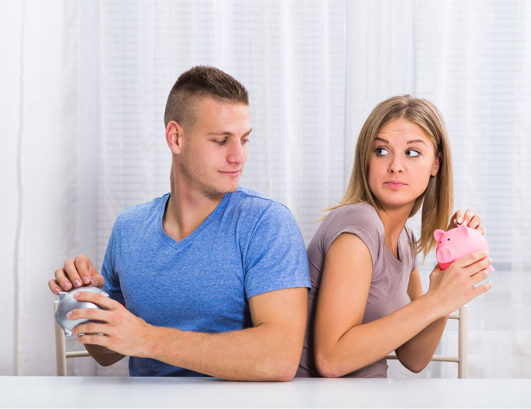 Man and woman each holding piggy banks with their backs turned