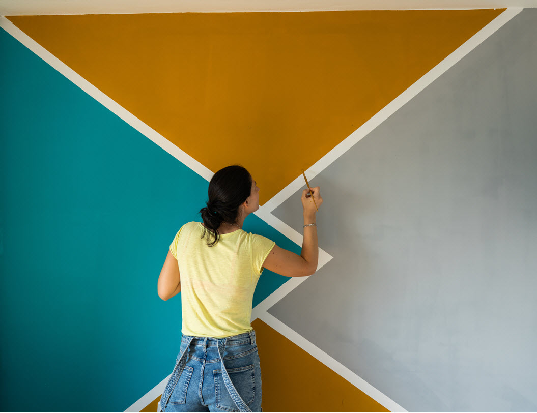 Woman painting the interior wall of a house