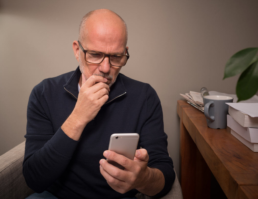 Man looking at a text scam on his phone