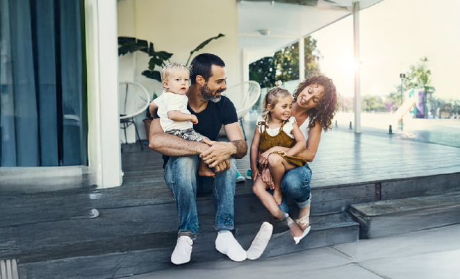 Mother, father, and two kids sitting on porch steps