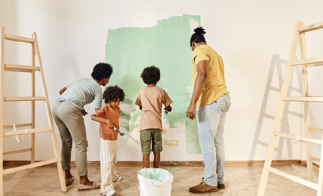 Family of four painting a room together
