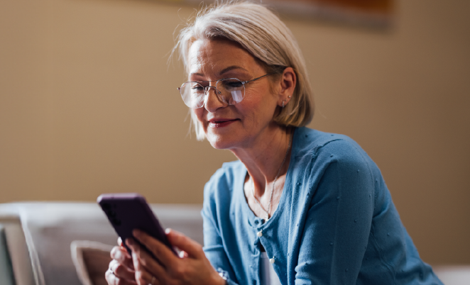 Woman sitting down, looking at her mobile phone