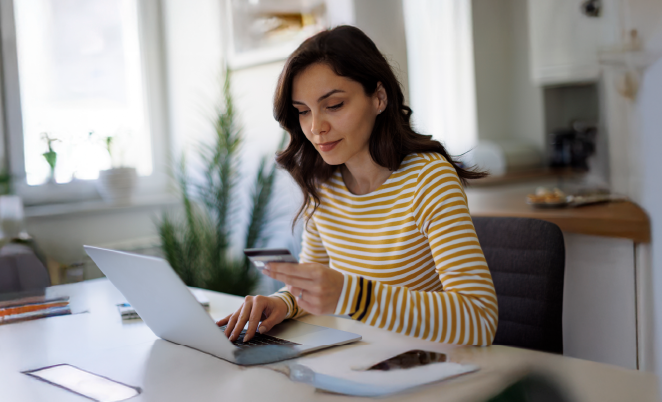 Woman using laptop paying for something with credit card