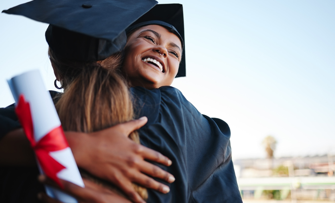 Two college graduates hugging