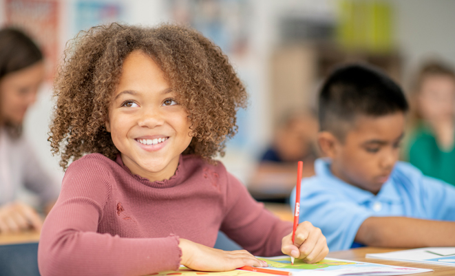 Young girl sitting at a desk in school
