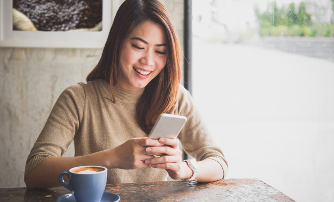Woman with coffee using her mobile device