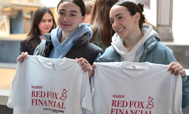 Two college students holding up Marist Red Fox Financial logo shirts