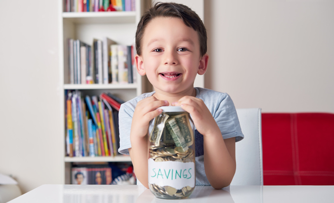 Boy holding a jar with money that is labeled Savings