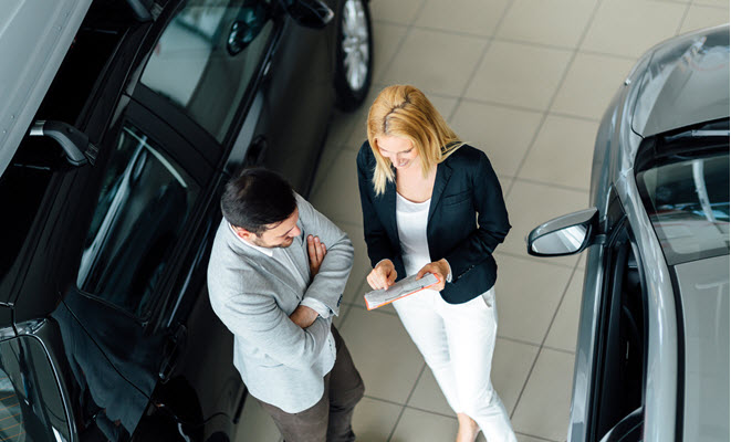 Man speaking with a car dealer in the showroom