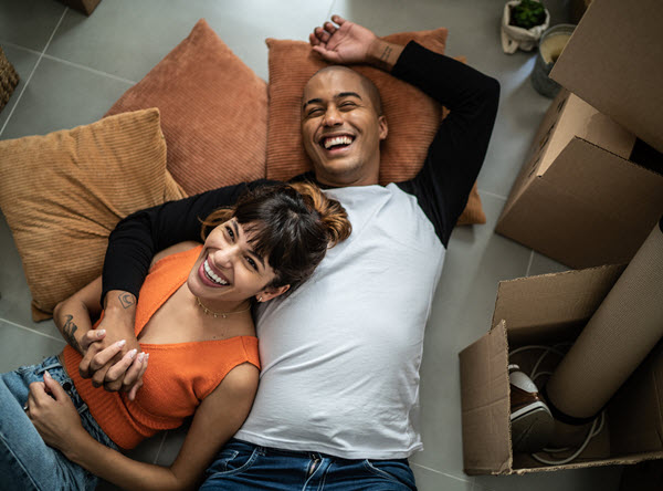 Young couple lying on the floor of their new home