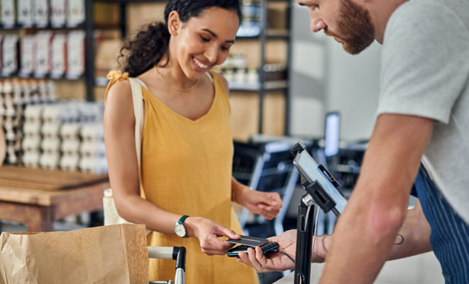 Woman paying with a card on a card reader